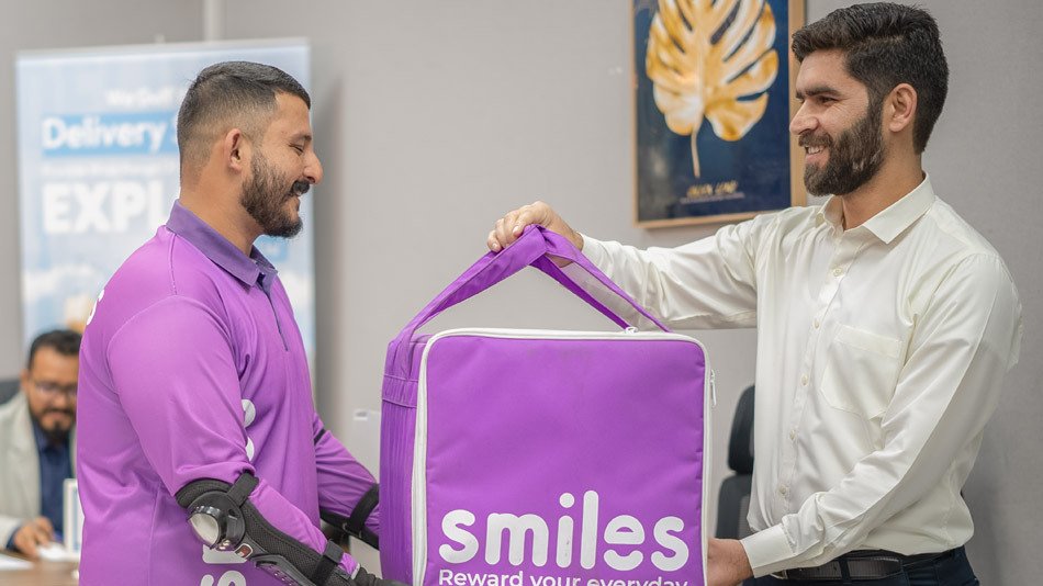 Emirates Way Delivery Services Operation team member giving smiles box to rider