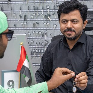 Emirates Way Delivery Services Operations Team Member Assigning Bike Keys to Rider