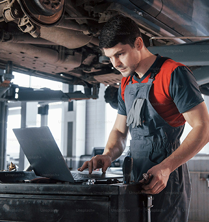 Emirates Way Delivery Services auto garage mechanic while analyzing the car performance in computer